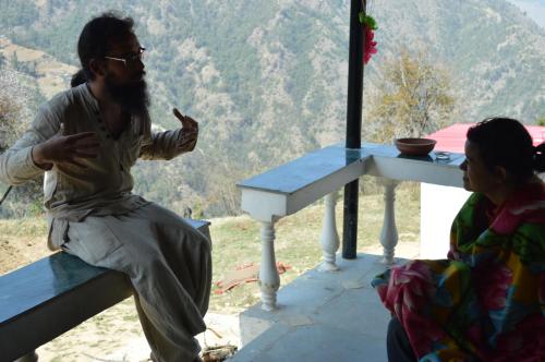 a man and a woman sitting at a table at Dhanaulti Camp Homes Retreat in Dhanaulti
