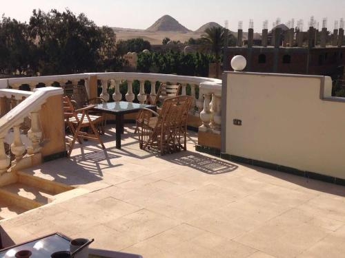 a patio with a table and chairs on a balcony at Sakkara pyramid inn hotel in Cairo