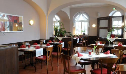 ein Restaurant mit Tischen, Stühlen und roten Servietten in der Unterkunft Hotel Döbelner Hof in Döbeln