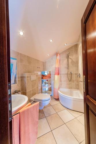 a bathroom with a tub and a toilet and a sink at daMonte – Apartments and rooms in Budva