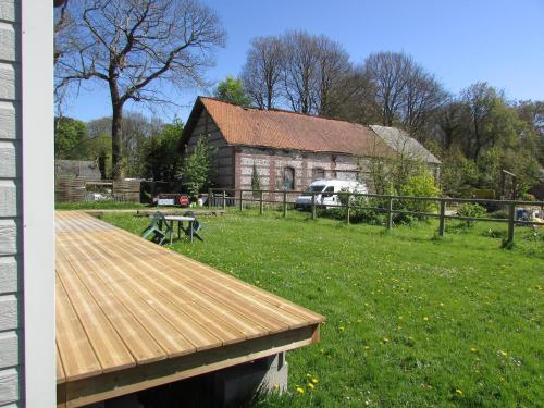 une terrasse en bois devant une grange dans l'établissement Etretat's Motel, à Étretat