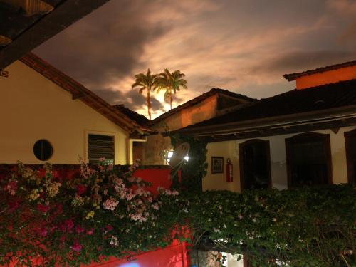 a house with a palm tree in the background at Pousada Marendaz in Paraty