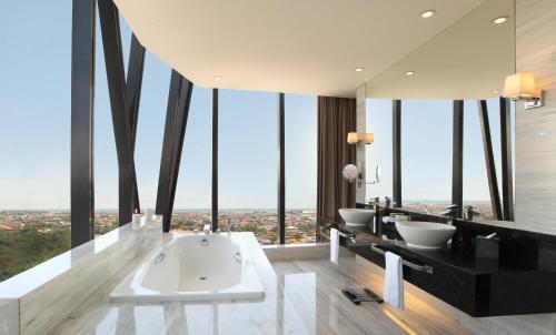 a bathroom with two sinks and a bath tub at PO Hotel Semarang in Semarang