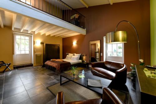 una habitación de hotel con una cama y un sofá en Domaine de Bel Air Carpe Diem, en Tizac-de-Curton