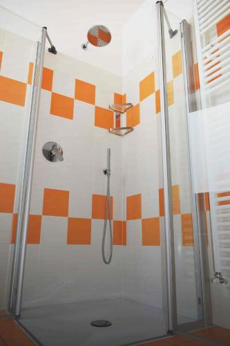 a bathroom with a shower with orange and white tiles at Residence Ambra in Riva del Garda