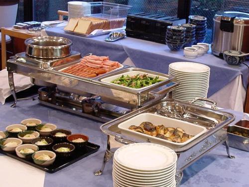 a buffet of food on a table with plates at Hotel Kunimi Gotenba in Gotemba