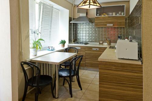 a kitchen with a table and chairs in a kitchen at Kyiv apartment on Starokyivskaya lane 5 in Kyiv