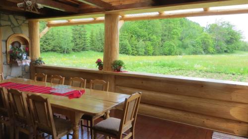 a dining room with a table and a large window at Pensiunea Poiana de Vis in Suceviţa