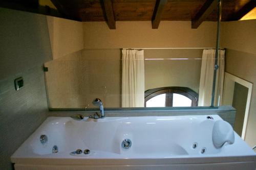 a white tub in a bathroom with a mirror at Casa Girardi in Peschiera del Garda