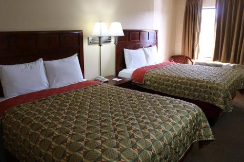 a hotel room with two beds and a window at Budget Inn Flagstaff in Flagstaff