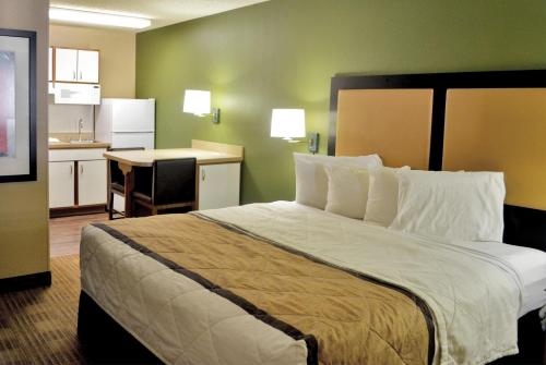 a hotel room with a large bed and a kitchen at Extended Stay America Select Suites - Atlanta - Perimeter - Hammond Drive in Atlanta