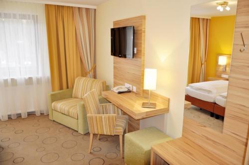 ein Hotelzimmer mit einem Schreibtisch und einem Bett in der Unterkunft Gasthof Landhotel Hubmann in Kleinlobming