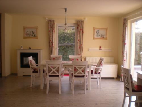 ein Esszimmer mit einem weißen Tisch und Stühlen in der Unterkunft Ferienhaus Arielle in Glowe