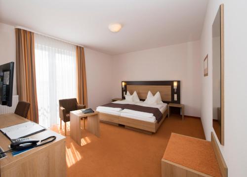 um quarto de hotel com uma cama e uma secretária em Landhotel Hopp Garni em Heßheim