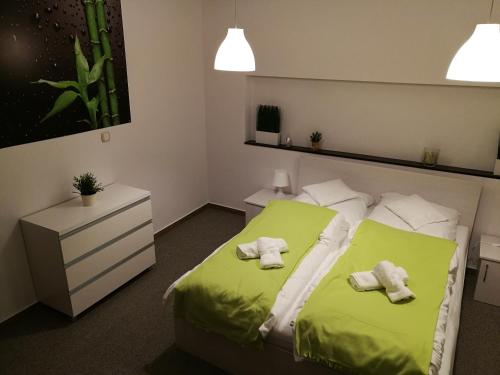 a bedroom with a green bed with two towels on it at Apartament na Różance in Wrocław