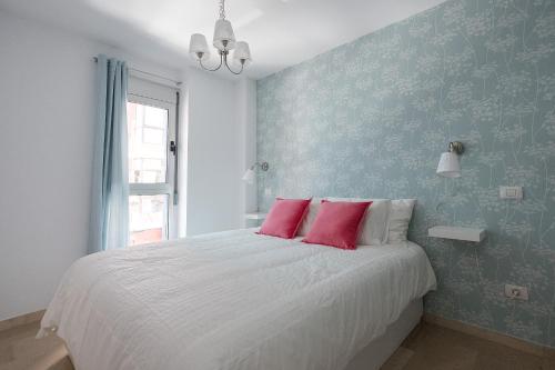 ラスパルマス・デ・グランカナリアにあるLas Palmas Lighthouse Apartmentのベッドルーム1室(ピンクの枕2つ、白いベッド1台付)