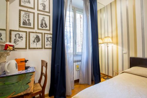 a bedroom with a bed with blue curtains and a window at Vatican Rooms Irene in Rome