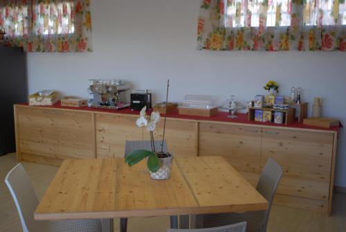 a wooden table with a vase with flowers on it at B&B Alciliegio in Casnate con Bernate