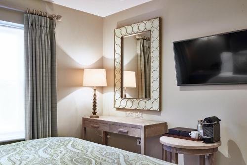 a hotel room with a bed and a mirror at Marquis Suffolk in Ipswich