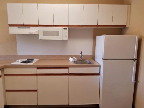 a kitchen with a white refrigerator and a sink at Extended Stay America Suites - Kansas City - Overland Park - Nall Ave in Overland Park