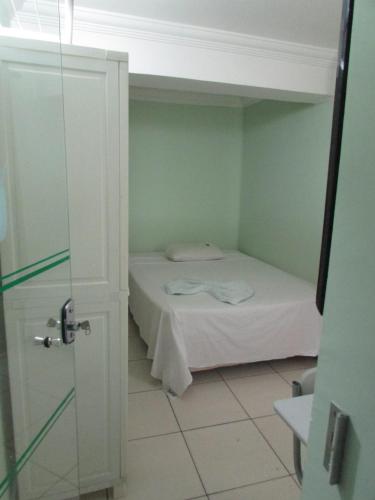 a small room with a bed and a shower at Hotel Industrial Contagem in Contagem