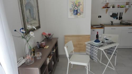 ポッツオーリにあるNew Flat in the Heart of Pozzuoliの小さなキッチン(テーブル、白い椅子付)