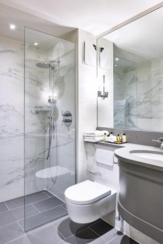 a bathroom with a toilet and a shower and a sink at Marquis Suffolk in Ipswich