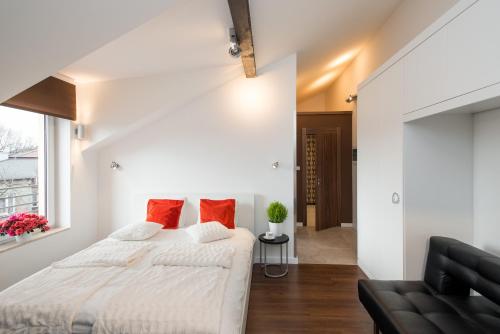 Habitación blanca con cama y sofá en Apartament nad dachami Krakowa en Cracovia