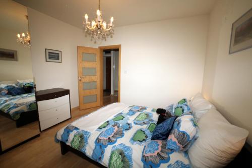 - une chambre avec un lit et un lustre dans l'établissement ASKI Powiśle Copernicus Apartment, à Varsovie