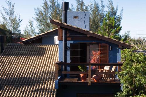 a tiny house with a roof on top of it at Surf a poucos passos do mar, casa com lareira in Garopaba