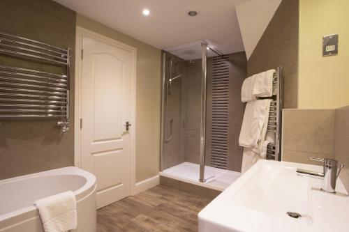 Stirrups Hotel في براكنيل: حمام مع حوض ومغسلة ودش