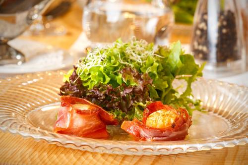 a plate of food with a salad on a table at Hotel & Restaurant zum Beck in Stansstad