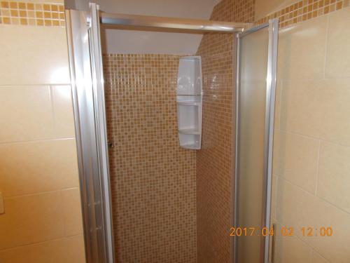 cabina de ducha con puerta de cristal y ducha acristalada en A Casa Di Monia, en Felline