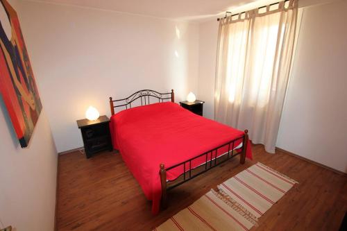 a bedroom with a red bed with two night stands at Apartment Dusanka in Fažana