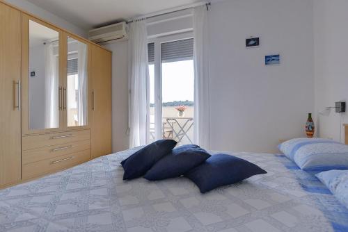 a bedroom with two blue pillows on a bed at Apartment Frlan in Ližnjan