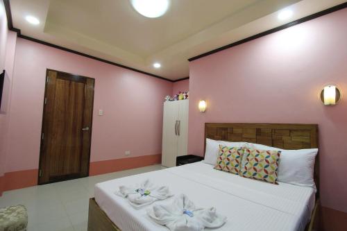 a bedroom with a bed with towels on it at Aquilah Homestay Inn in Coron
