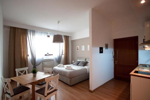 ローマにあるAlbornoz 35のベッド、テーブル、キッチンが備わる小さなアパートメントです。
