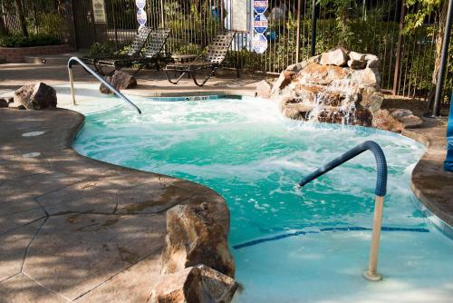 a plunge pool with a waterfall in a backyard at Tahiti Village Resort & Spa in Las Vegas