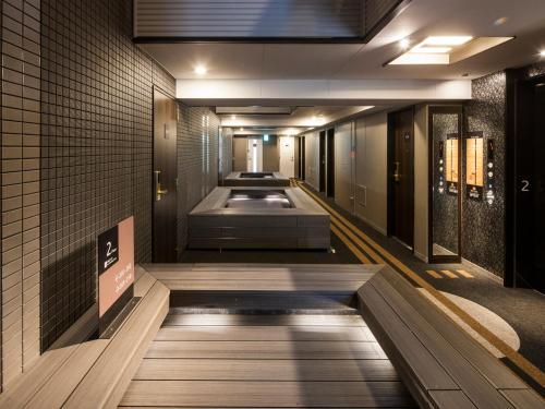 a walkway in a building with a row of baths at APA Hotel Higashi Shinjuku Kabukicho Higashi in Tokyo