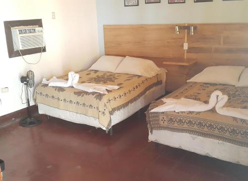 a room with two beds with towels on them at Playa Roca Beach Hotel in Las Peñitas