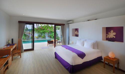 a hotel room with a bed and a desk and a bedroom at Anema Wellness & Resort Gili Lombok - Diving Center PADI in Tanjung