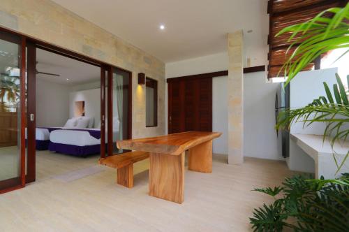 a wooden bench in a room with a bedroom at Anema Wellness & Resort Gili Lombok - Diving Center PADI in Tanjung