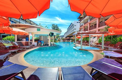 a swimming pool with tables and umbrellas at a hotel at Kata Sea Breeze Resort - SHA Plus in Kata Beach