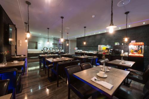ein Restaurant mit Tischen und Stühlen und eine Bar in der Unterkunft Forward Suites Ⅰ in Taipeh