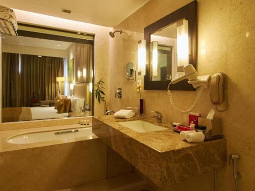 een badkamer met een wastafel en een grote spiegel bij The Gateway Hotel Beach Road Visakhapatnam in Visakhapatnam