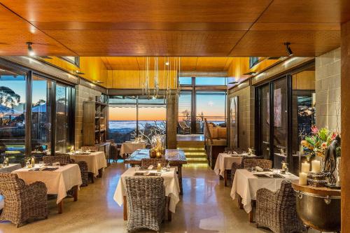 a dining room with tables and chairs and windows at Spicers Sangoma Retreat - Adults Only in Kurrajong