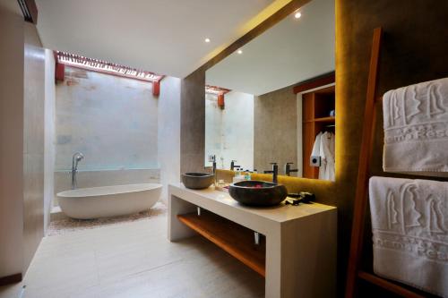 a bathroom with a tub and a sink and a bath tub at Anema Wellness Villa & Spa Gili Lombok - Diving Center PADI in Tanjung