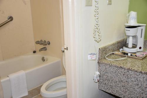 a bathroom with a toilet and a coffee maker on a counter at Super 8 by Wyndham Tifton in Tifton