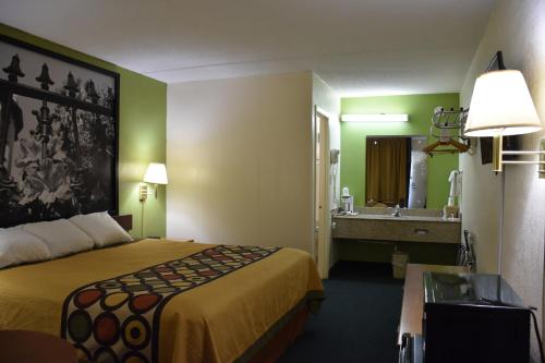 a hotel room with a bed and a sink at Super 8 by Wyndham Tifton in Tifton
