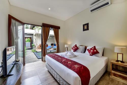 a bedroom with a large bed and a television at Yoga Ubud Private Pool Villa in Ubud